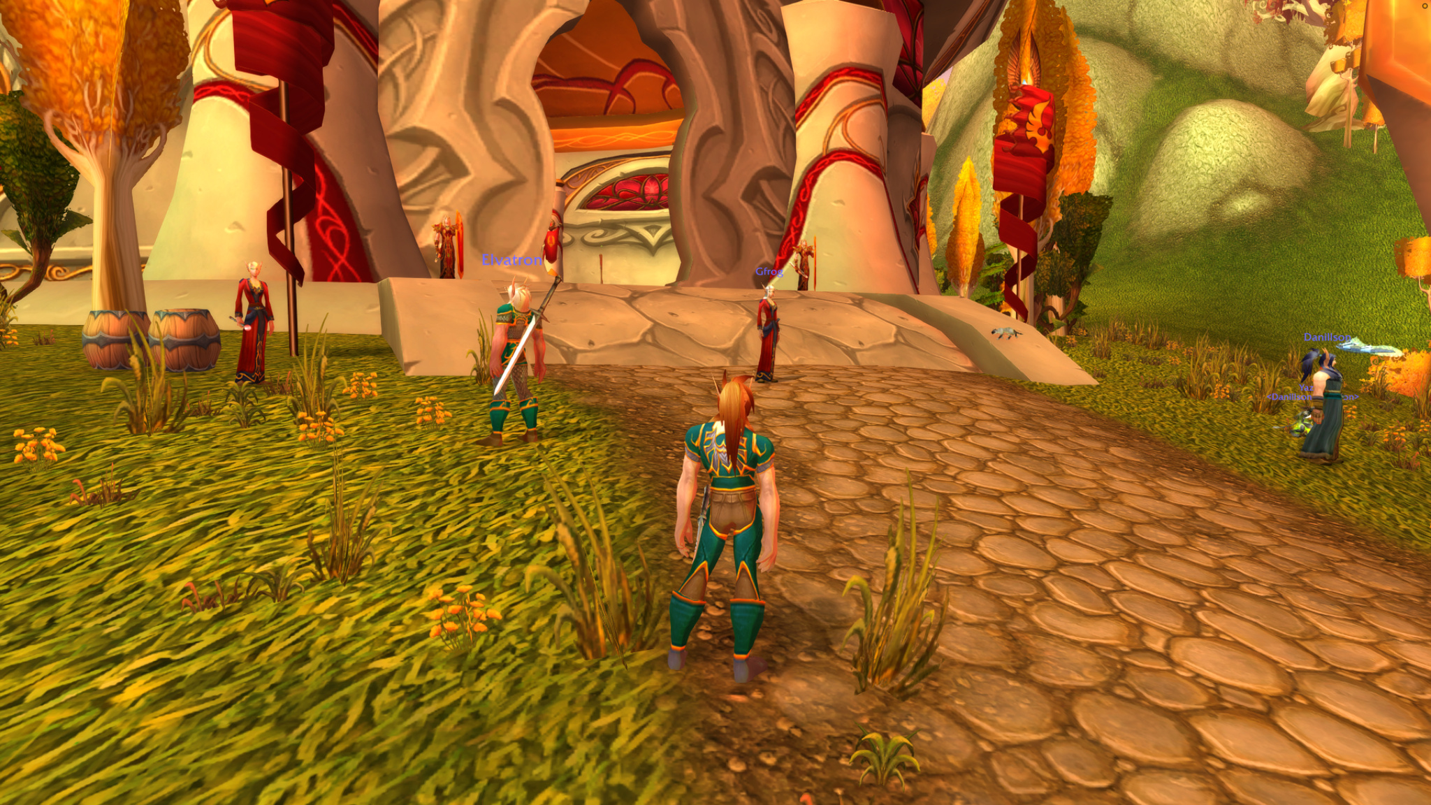A blood elf approaches a hunter in green and gold outside an ornate elven building among golden trees.